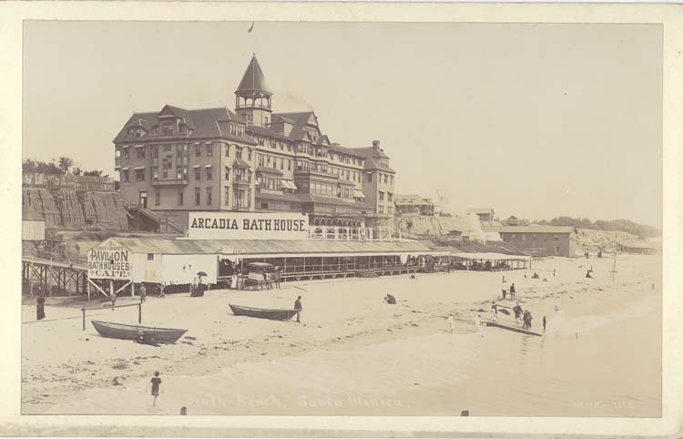 This photograph shows the Arcadia bathhouse facing a boat-littered beach.